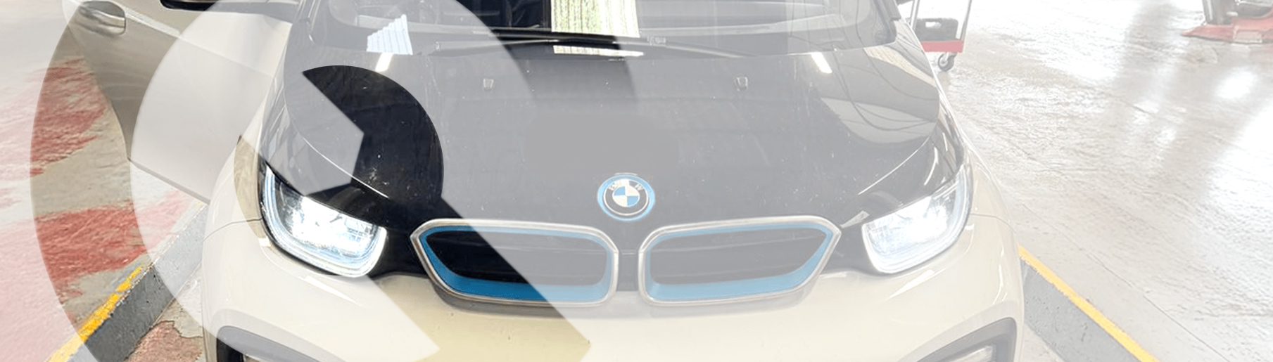an image of a BMW i series at Castle Garage EV in Ashby. There's a white, sheer overlay with the Castle Garage icon shape being clearer than the rest of the overlay